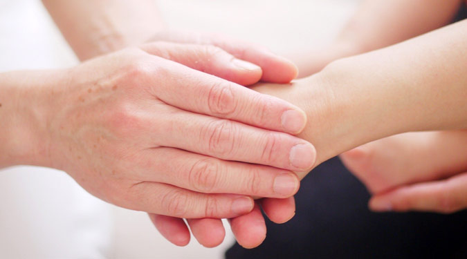 Parent's hand holding a child's hand