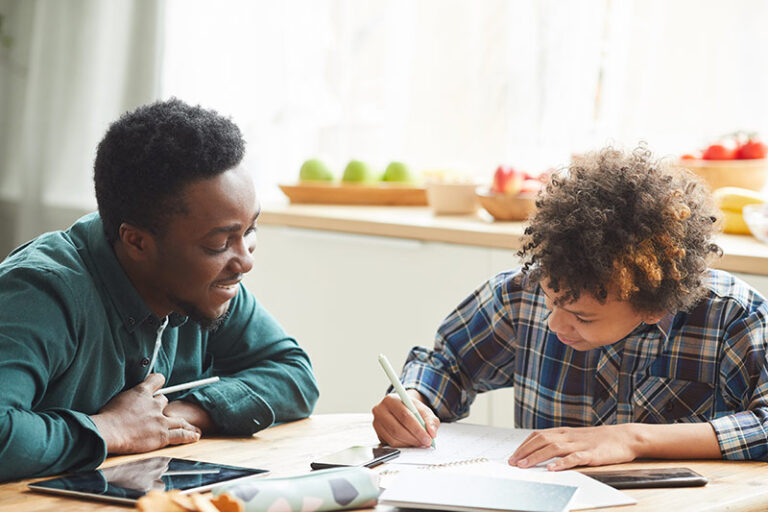 Parent helping student with school work at the kitchen table