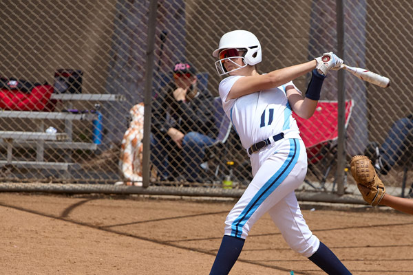 Girl swinging bat playing softball