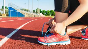 Woman tying shoes on running track